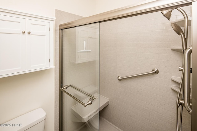 bathroom featuring toilet and a tile shower