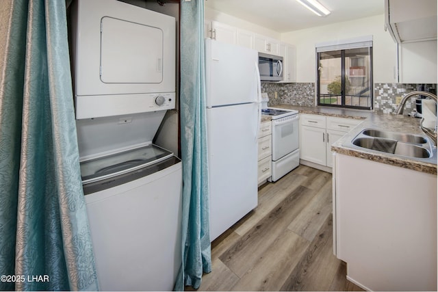 500 S Lake Havasu Ave N Unit A12, Lake Havasu City, AZ 86403 - kitchen with light wood finished floors, stacked washer / dryer, a sink, white appliances, and tasteful backsplash