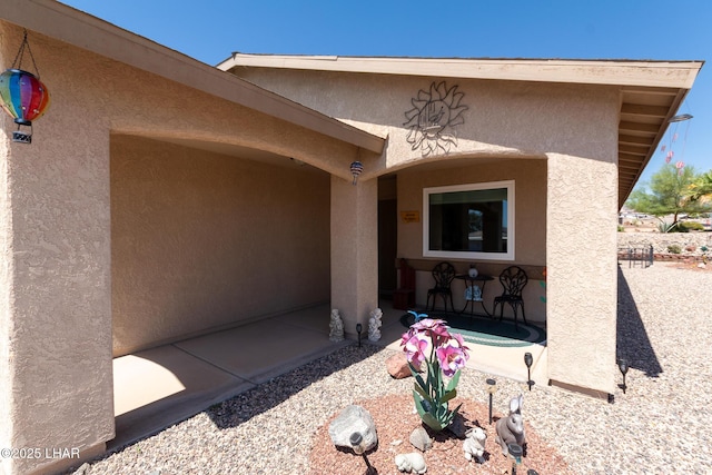 entrance to property with a patio area and stucco siding