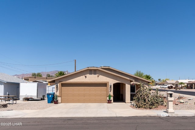 single story home featuring a garage, stucco siding, and concrete driveway