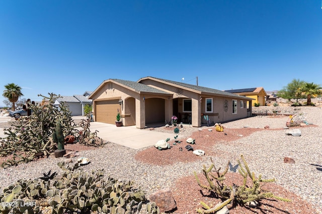 view of front of home featuring an attached garage, driveway, and stucco siding
