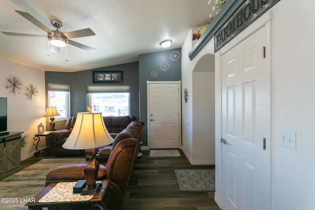 living room featuring baseboards, vaulted ceiling, wood finished floors, and ceiling fan