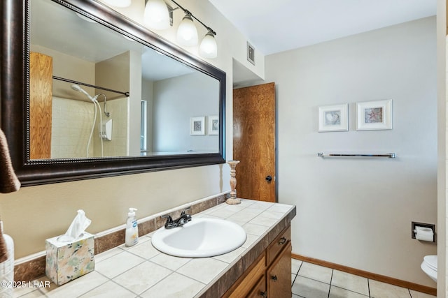 bathroom featuring visible vents, vanity, baseboards, and tile patterned floors