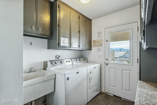 clothes washing area featuring dark wood-style flooring, cabinet space, a sink, and washer and clothes dryer