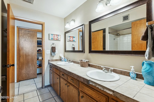 full bathroom with double vanity, visible vents, a sink, and tile patterned floors