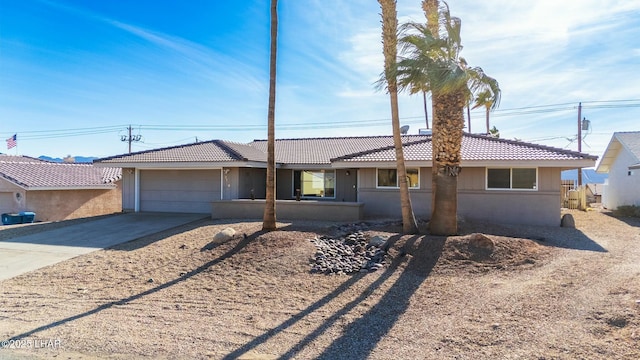 ranch-style home featuring driveway, an attached garage, and stucco siding