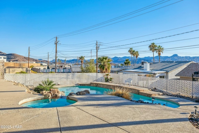 view of pool featuring a patio area, fence, a mountain view, and a fenced in pool