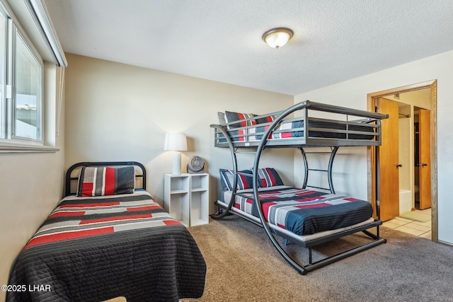 bedroom featuring light colored carpet and a textured ceiling