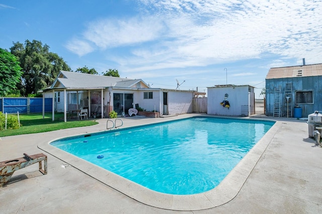 view of swimming pool featuring an outbuilding and a patio