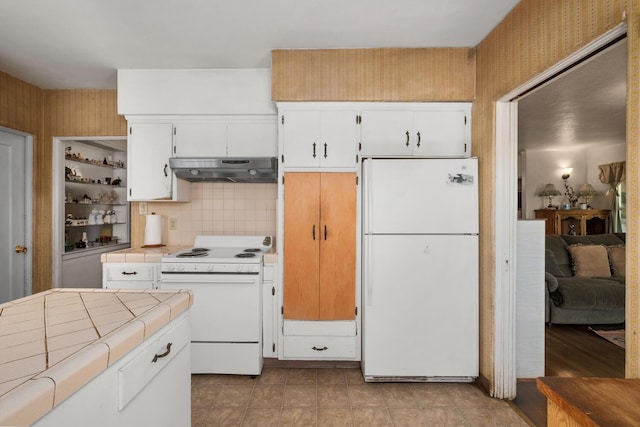 kitchen with light tile patterned floors, white appliances, tasteful backsplash, and tile countertops