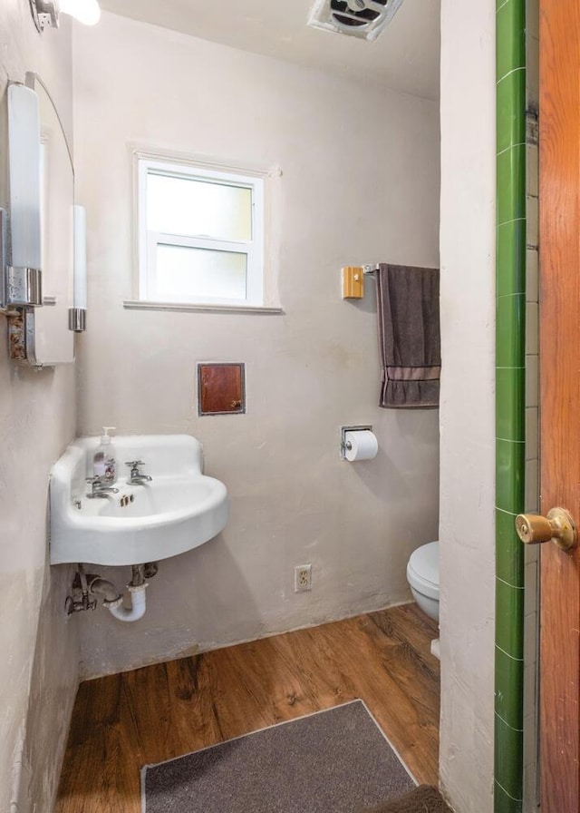 bathroom featuring wood-type flooring, sink, and toilet