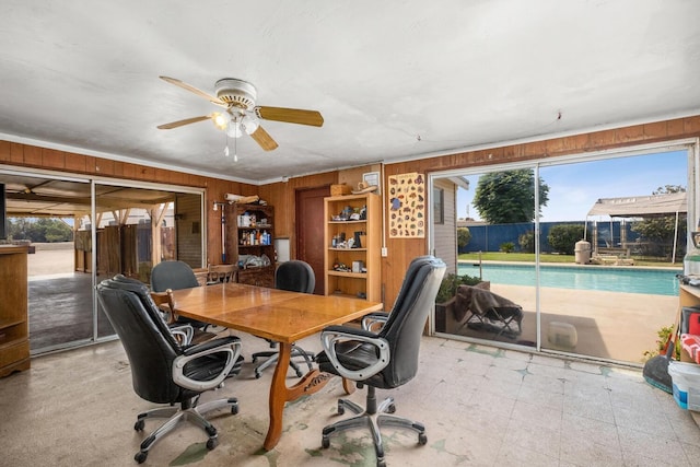 office area with ceiling fan, wood walls, and plenty of natural light