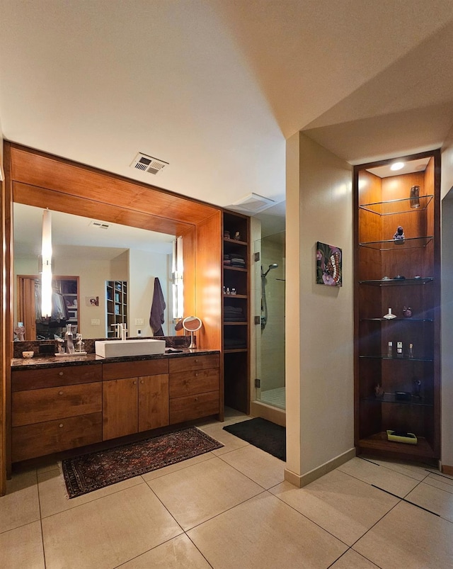 bathroom with tile patterned flooring, vanity, and a shower with shower door