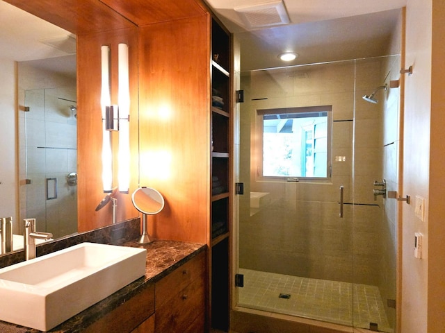 bathroom featuring vanity and a shower with door