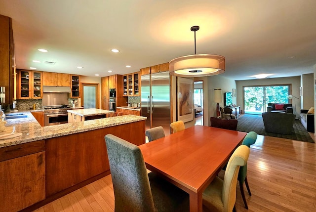 dining room with sink and light hardwood / wood-style flooring