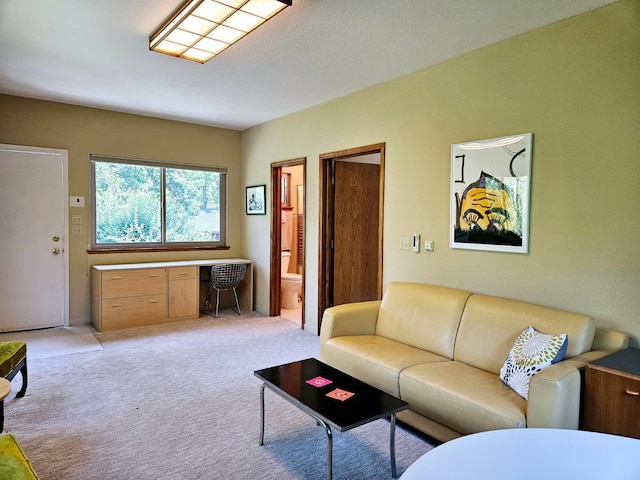 living room featuring light carpet and built in desk