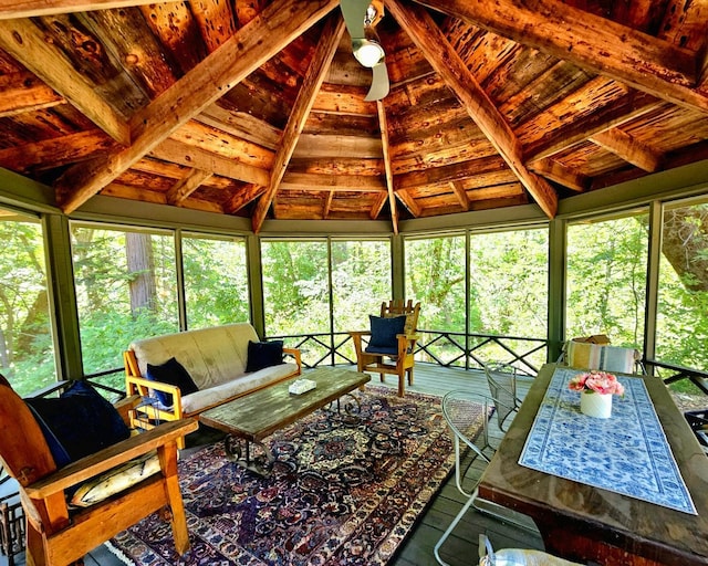 sunroom / solarium featuring ceiling fan, lofted ceiling with beams, and wooden ceiling