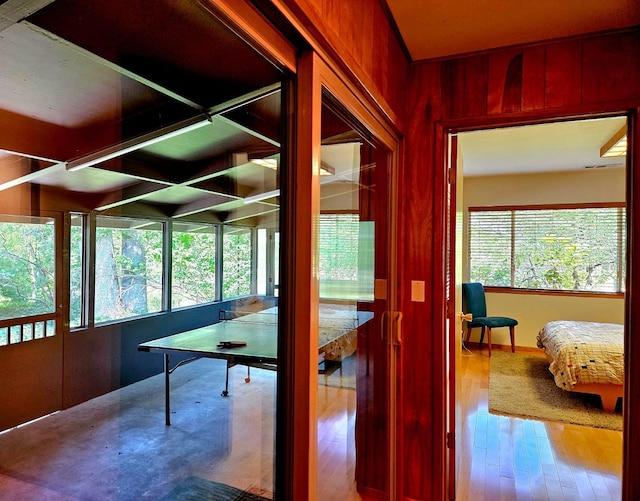 recreation room with hardwood / wood-style floors and wooden walls