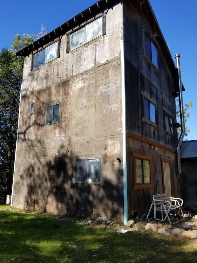 view of side of property with a lawn