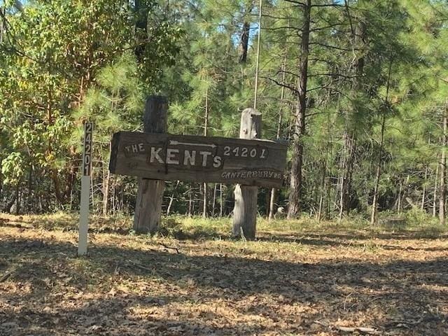 community / neighborhood sign with a view of trees