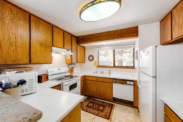 kitchen featuring sink, light tile patterned floors, and white appliances