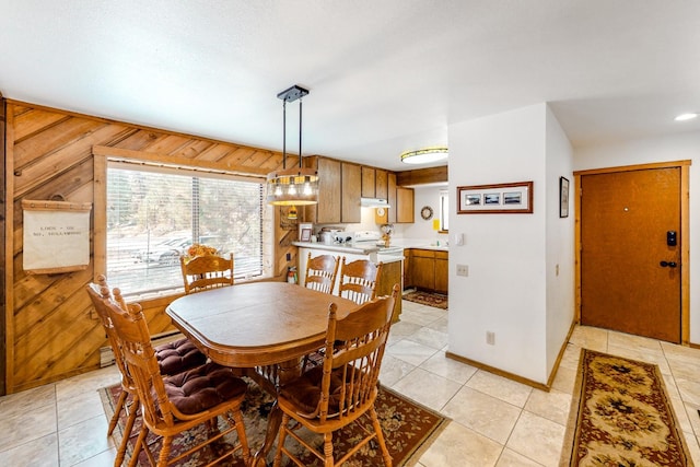 tiled dining space featuring wood walls