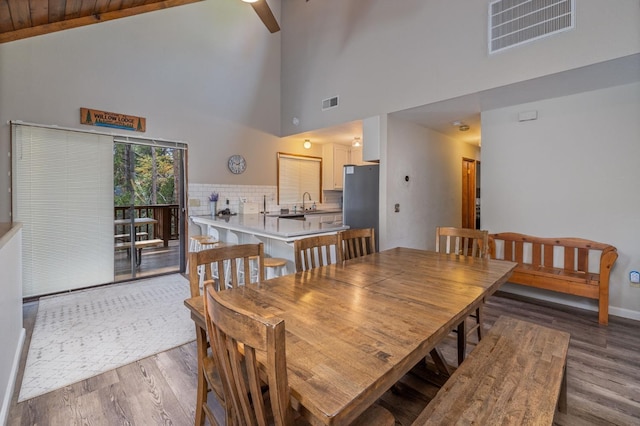 dining space with vaulted ceiling, dark hardwood / wood-style floors, and sink