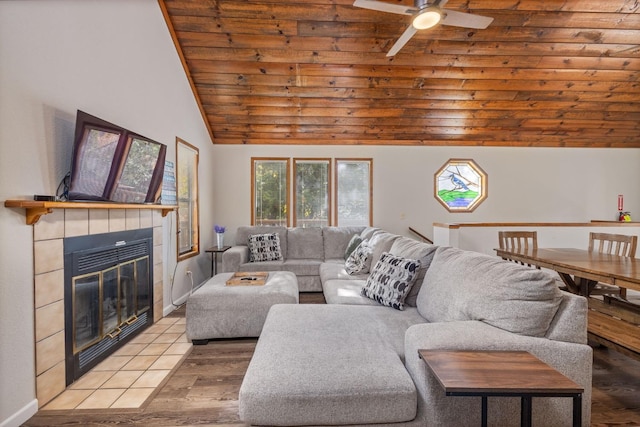 living room with a tiled fireplace, wood ceiling, lofted ceiling, and ceiling fan