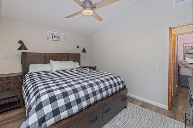 bedroom with ceiling fan, lofted ceiling, and light wood-type flooring