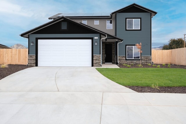 view of front facade with solar panels, a front lawn, and a garage