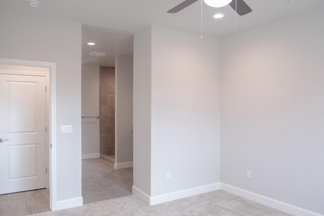 carpeted spare room featuring ceiling fan