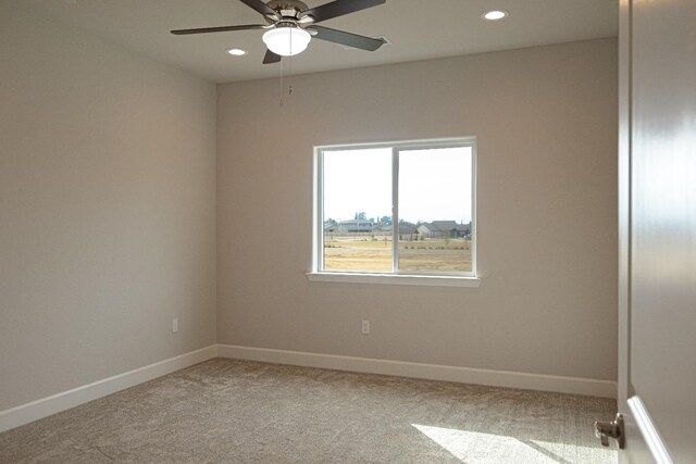 unfurnished room with ceiling fan and light colored carpet