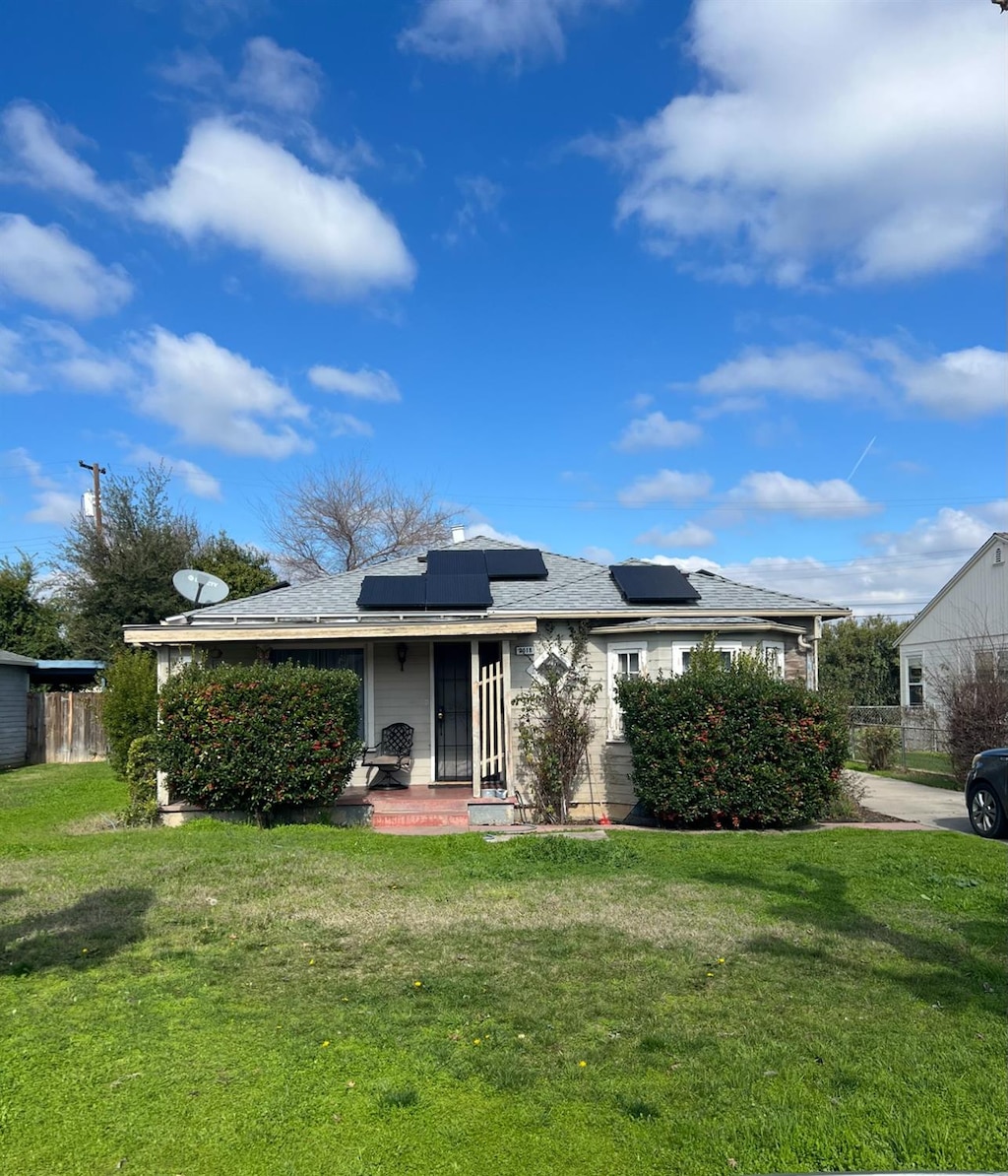exterior space with solar panels and a yard