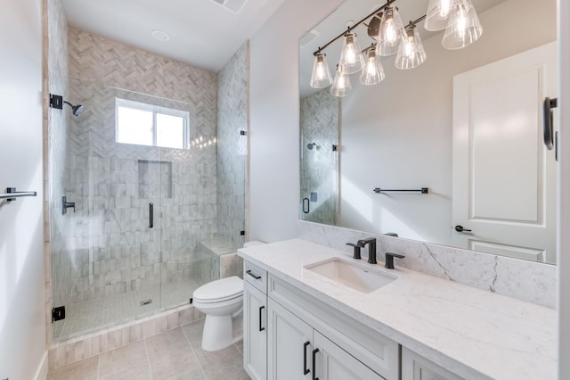 bathroom featuring visible vents, toilet, a shower stall, vanity, and tile patterned floors