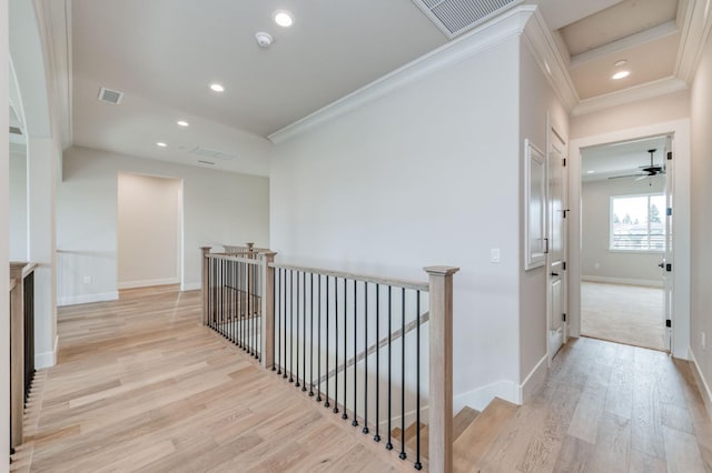 hallway featuring visible vents, light wood-style flooring, an upstairs landing, and crown molding