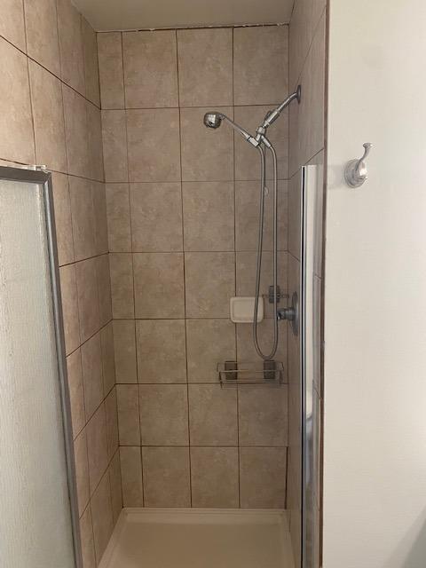 bathroom featuring a shower with door