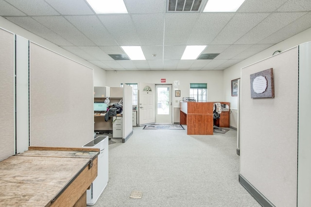 office area featuring visible vents, light colored carpet, and a paneled ceiling