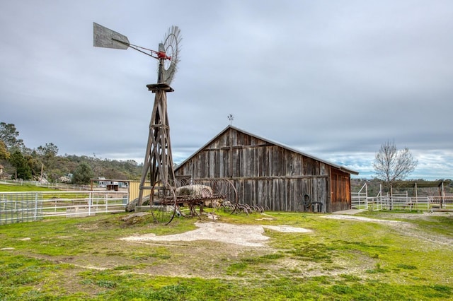 view of yard featuring an outbuilding, a barn, and fence