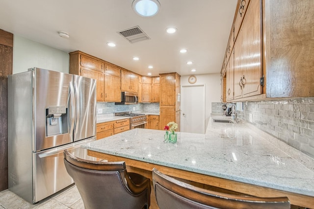 kitchen with light tile patterned floors, visible vents, a peninsula, a sink, and stainless steel appliances