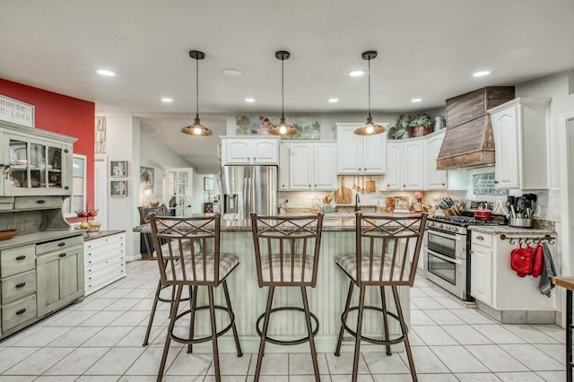kitchen with a breakfast bar area, light tile patterned floors, decorative backsplash, appliances with stainless steel finishes, and white cabinets