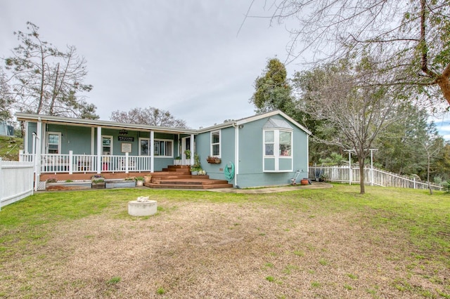 view of front of house with a front yard, fence, and covered porch