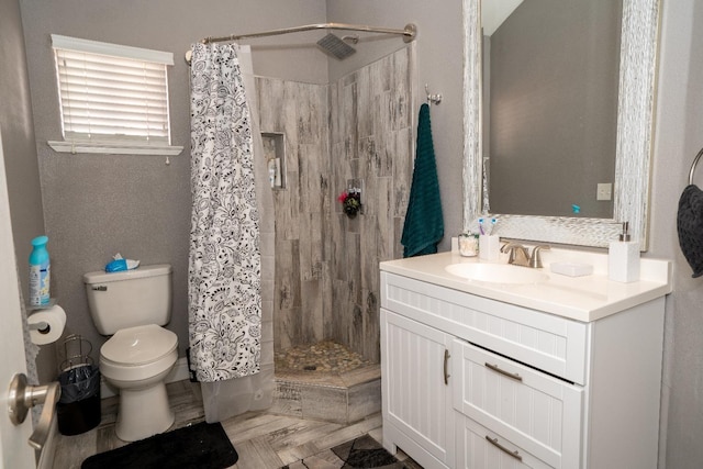 bathroom featuring curtained shower, vanity, and toilet