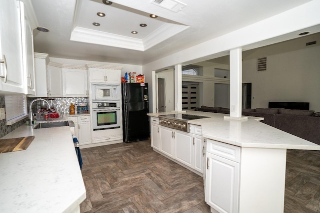 kitchen featuring white cabinets, a raised ceiling, and appliances with stainless steel finishes