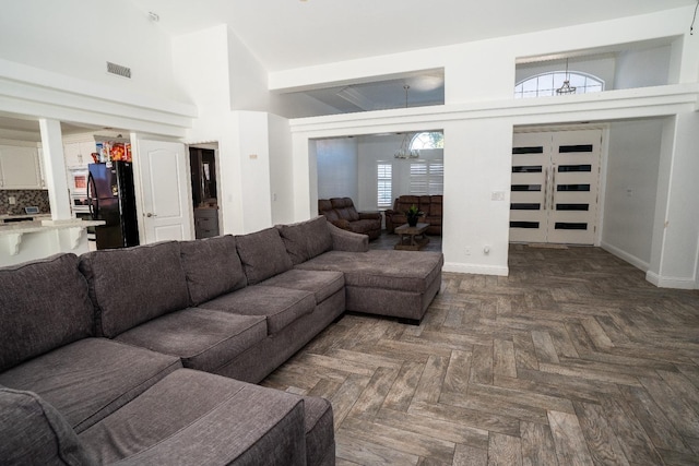 living room featuring dark parquet flooring and a towering ceiling