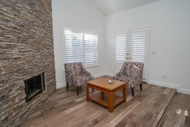 sitting room featuring a fireplace, wood-type flooring, and vaulted ceiling