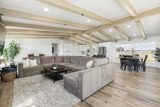 living room featuring light hardwood / wood-style floors and vaulted ceiling with beams