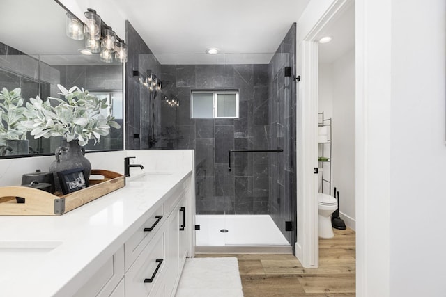 bathroom featuring hardwood / wood-style flooring, vanity, toilet, and walk in shower