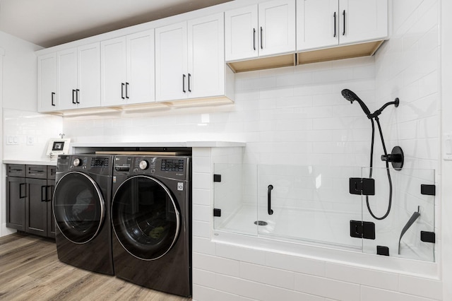 clothes washing area featuring independent washer and dryer and light hardwood / wood-style floors