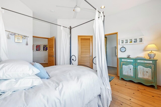 bedroom with vaulted ceiling, ceiling fan, and light wood-type flooring