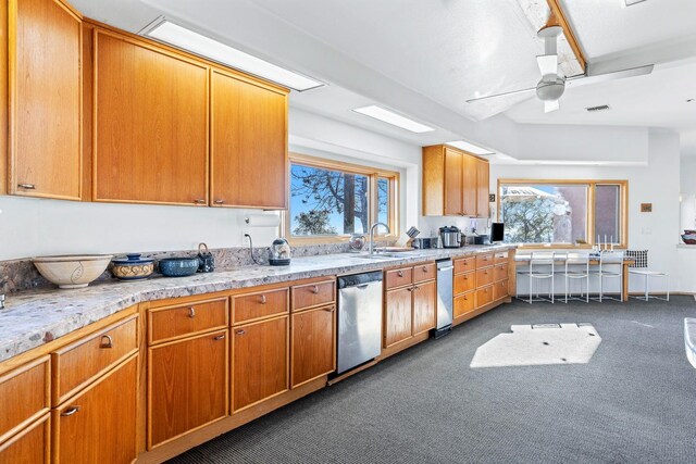 kitchen with stainless steel dishwasher, light colored carpet, and a healthy amount of sunlight